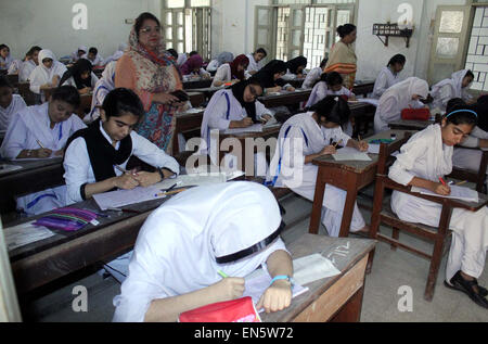 Des élèves du niveau intermédiaire de résoudre les feuilles d'examen au cours de l'examen annuel 2015 à une salle d'examen que les examens intermédiaires ont été lancées dans le cadre du Conseil de l'éducation régionaux Karachi mardi, 28 avril 2015. Banque D'Images