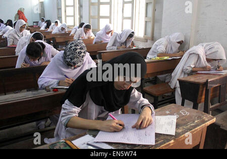 Des élèves du niveau intermédiaire de résoudre les feuilles d'examen au cours de l'examen annuel 2015 à une salle d'examen que les examens intermédiaires ont été lancées dans le cadre du Conseil de l'éducation régionaux Karachi mardi, 28 avril 2015. Banque D'Images