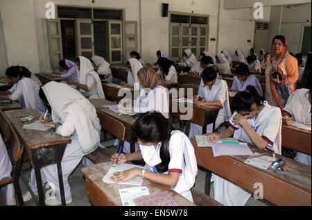 Des élèves du niveau intermédiaire de résoudre les feuilles d'examen au cours de l'examen annuel 2015 à une salle d'examen que les examens intermédiaires ont été lancées dans le cadre du Conseil de l'éducation régionaux Karachi mardi, 28 avril 2015. Banque D'Images