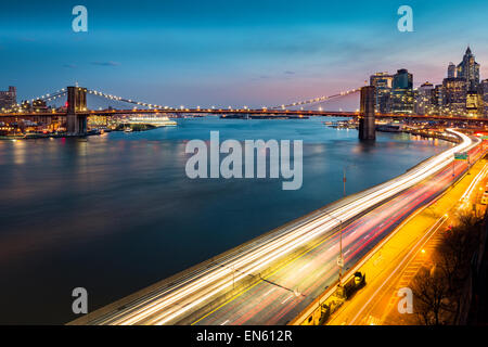 Pont de Brooklyn et le trafic avec des sentiers sur le FDR Drive at Dusk Banque D'Images