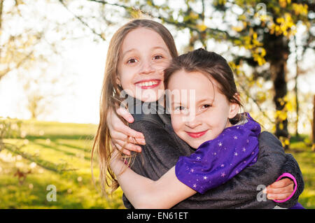 Sœurs sourire hug Banque D'Images