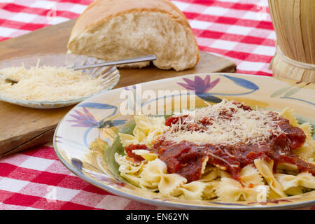 Les pâtes italiennes dîner servi avec sauce Marinara, parmesan, plus de nouilles papillon accompagné d'un verre de vin Chianti un Banque D'Images