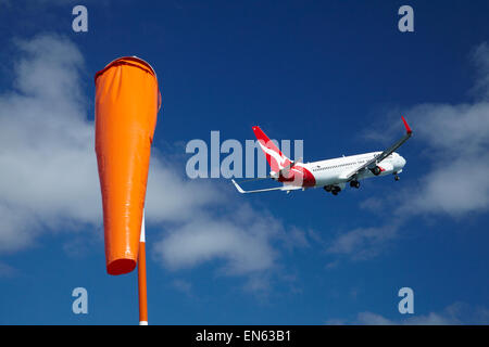 Manche à vent, et Qantas Boeing 737-800 décollant de l'Aéroport International de Wellington, Wellington, Île du Nord, Nouvelle-Zélande Banque D'Images