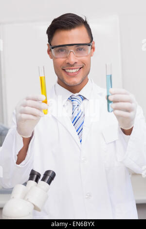 Smiling scientist examining précipite dans des tubes Banque D'Images