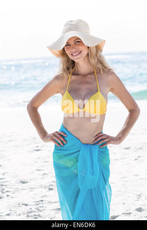 Smiling jolie blonde posant avec jupe et chapeau de paille Banque D'Images