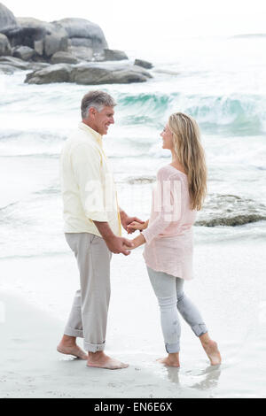 Heureux couple holding hands and smiling at each other Banque D'Images