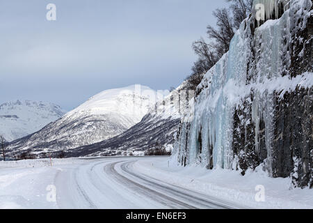 Route qui traverse les montagnes enneigées du nord de la Norvège Banque D'Images