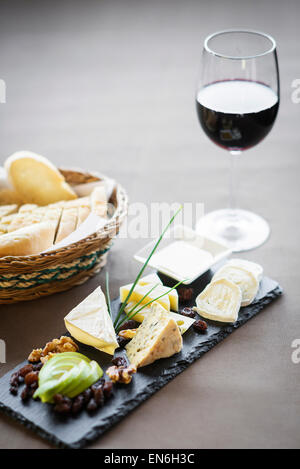 Plateau de fromages français mélangés avec le verre de vin rouge et du pain Banque D'Images