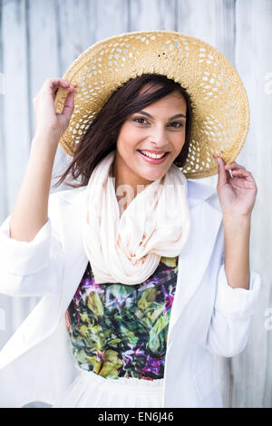Smiling beautiful brunette wearing straw hat and looking at camera Banque D'Images