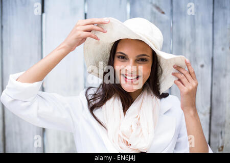 Smiling beautiful brunette wearing straw hat and looking at camera Banque D'Images