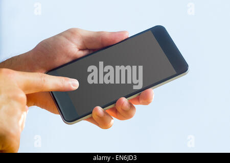 Main tenant un smartphone noir Banque D'Images
