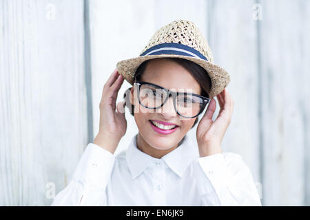 Jolie brunette looking at camera avec les mains de hat Banque D'Images