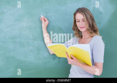 Smiling teacher writing on blackboard Banque D'Images