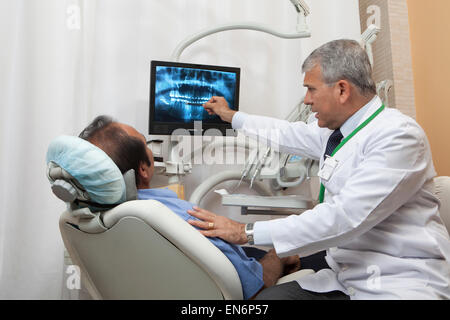 Dentist showing patient x-ray de dents Banque D'Images