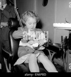 Fille dans le fauteuil du dentiste à une clinique dentaire pour les enfants. 1954. Banque D'Images