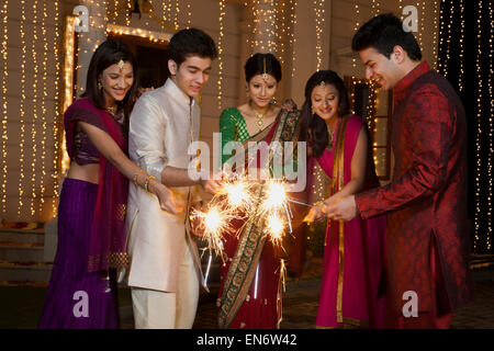 Amis jouant avec les cierges magiques Banque D'Images