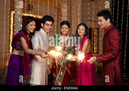 Amis jouant avec les cierges magiques Banque D'Images