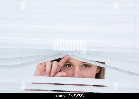 Woman peering par rouleau Banque D'Images