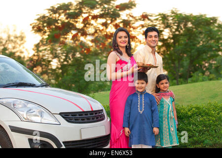 Portrait de famille se tenant debout à côté de nouvelle voiture Banque D'Images