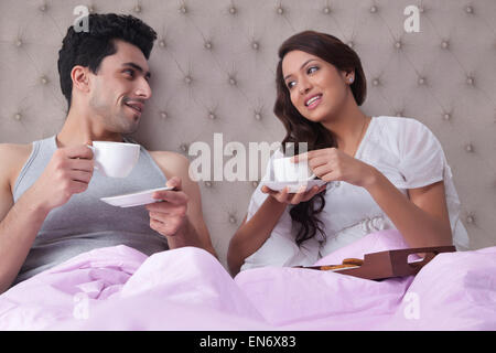 Couple having coffee in bed Banque D'Images