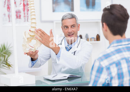 Médecin montrant son patient un modèle de colonne vertébrale Banque D'Images