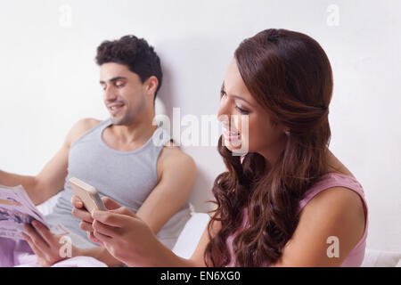 Femme lisant un sms sur un téléphone mobile Banque D'Images