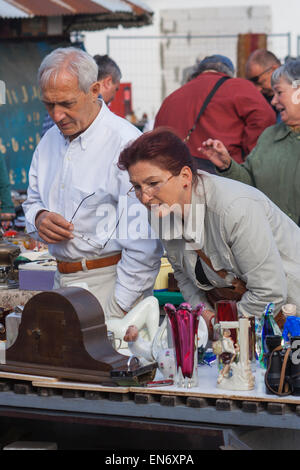 Couple d'âge moyen l'étude des antiquités à un marché aux puces à l'extérieur de Budapest, Hongrie Banque D'Images