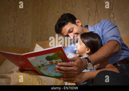 Père de lire une histoire à sa fille Banque D'Images