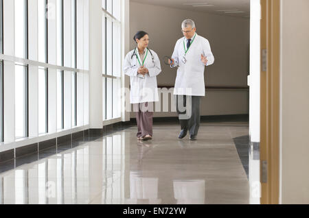 Deux médecins qui parlent in hospital corridor Banque D'Images