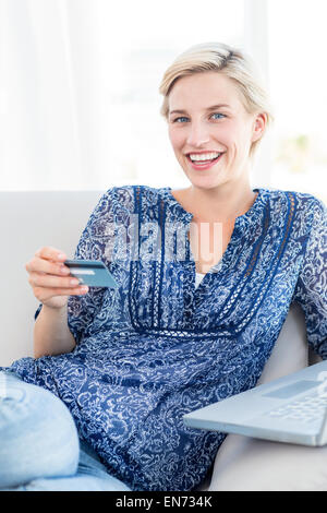Jolie blonde woman doing online shopping Banque D'Images