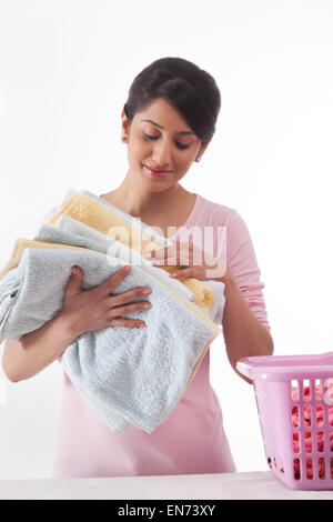 Jeune femme tenant une pile de serviettes Banque D'Images