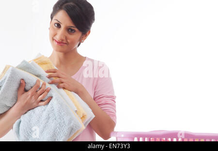 Jeune femme tenant une pile de serviettes Banque D'Images