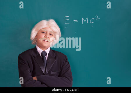 Portrait de garçon vêtu comme Einstein avec équation mathématique Banque D'Images