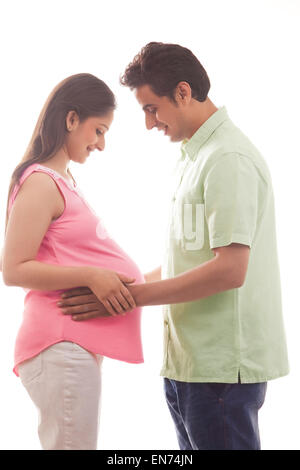 L'homme avec les mains sur l'estomac de femme enceinte Banque D'Images