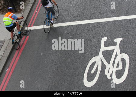 Deux cyclistes équitation à travers une zone de cyclisme dans la rue à Londres, Angleterre Banque D'Images