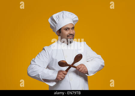 Portrait de chef holding cuillères en bois Banque D'Images
