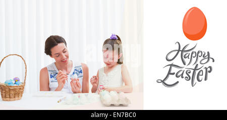 Image composite de mère et fille painting Easter eggs Banque D'Images
