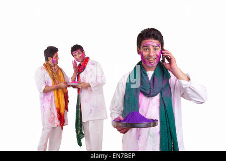 Portrait d'un homme avec des couleurs holi talking on a mobile phone Banque D'Images
