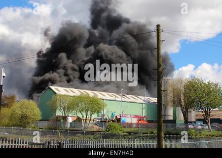 Oldbury, West Midlands, Royaume-Uni. 29 avril, 2015. Jusqu'à 75 pompiers s'attaquent à un grand incendie qui s'est déclaré dans une zone industrielle de Oldbury. Des panaches de fumée peut être vu à des kilomètres à la ronde. L'établissement à l'Tat Bank Road appartient à Teknor Apex limitée. Il y a des soucis dans la région si les vapeurs peuvent être toxiques. Crédit : Robert Clarke/Alamy Live News Banque D'Images