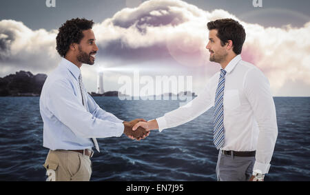 Portrait of young businessmen shaking hands in office Banque D'Images