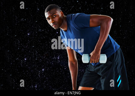 Composite image of casual young man lifting dumbbell Banque D'Images