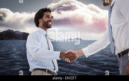 Image composite de deux businessmen shaking hands in office Banque D'Images