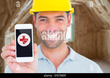 Image composite de portrait of smiling handyman montrant smart phone Banque D'Images