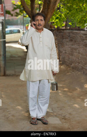 Man talking on cell phone et holding bidon de lait Banque D'Images