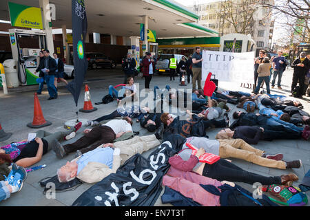 Les manifestants exécuter 'Die' chez BP British Petroleum / remplissage essence parvis de la gare pendant une démocratie vs TTIP Journée d'action. Banque D'Images