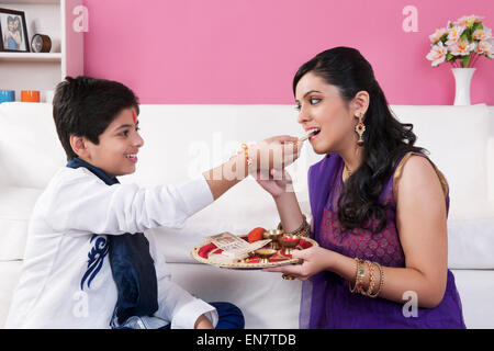 Bonbons alimentation frère à sa sœur à Raksha Bandhan Banque D'Images