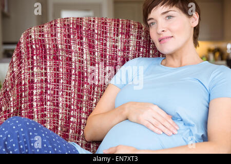 Femme enceinte détente sur le canapé Banque D'Images