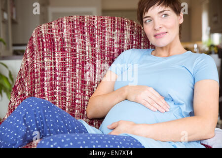 Femme enceinte détente sur le canapé Banque D'Images