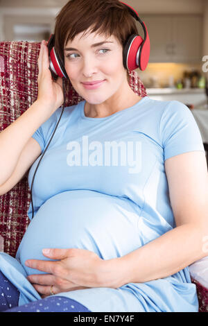 Femme enceinte en mettant plus de casque bump Banque D'Images