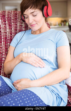 Femme enceinte à écouter de la musique Banque D'Images